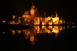 Fairytale silhouette of Český Krumlov Castle reflected in the calm river at sunset.