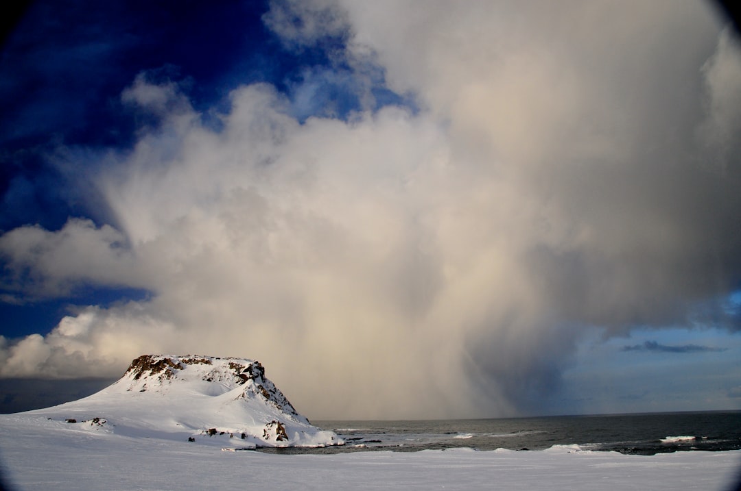 white cloud over the sea near snow covered shore