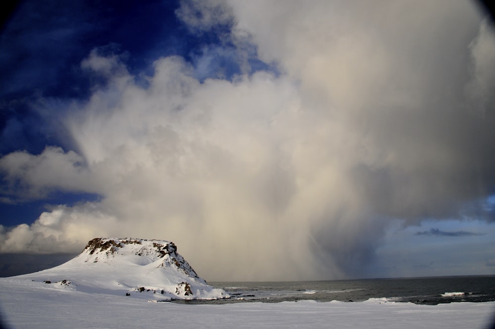 white cloud over the sea near snow covered shore