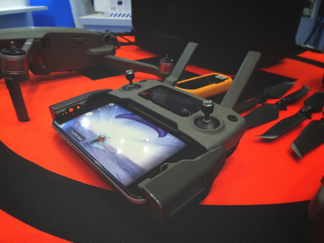 black game controller near gray drone