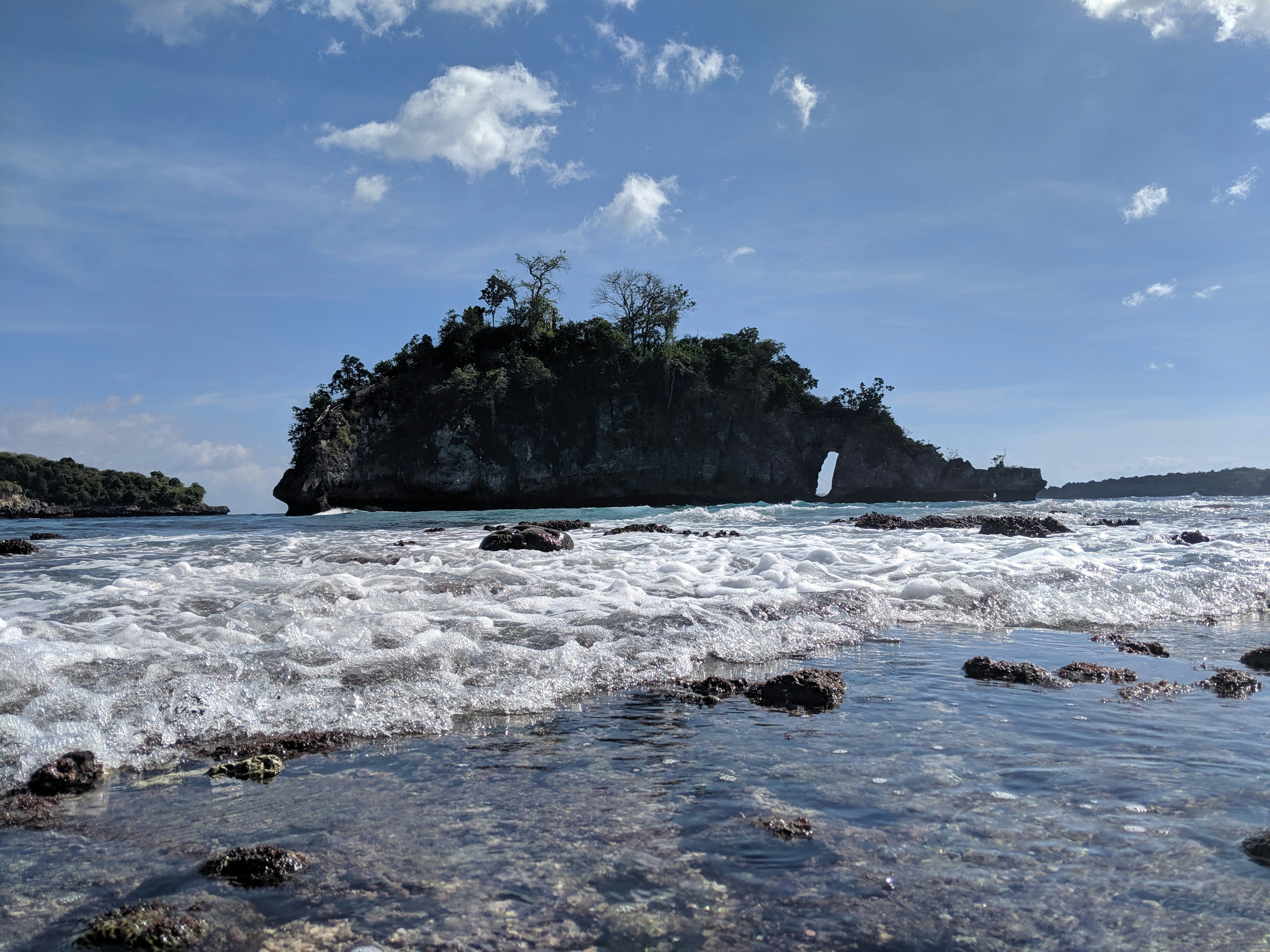 body of water near mountain at daytime