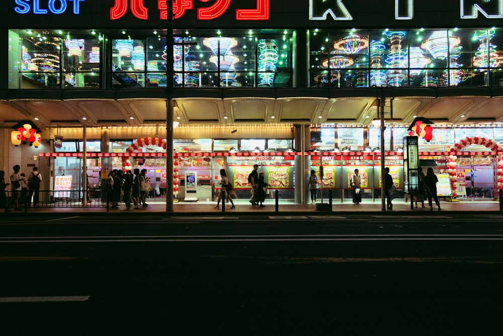 people walking near glass walled building during night time