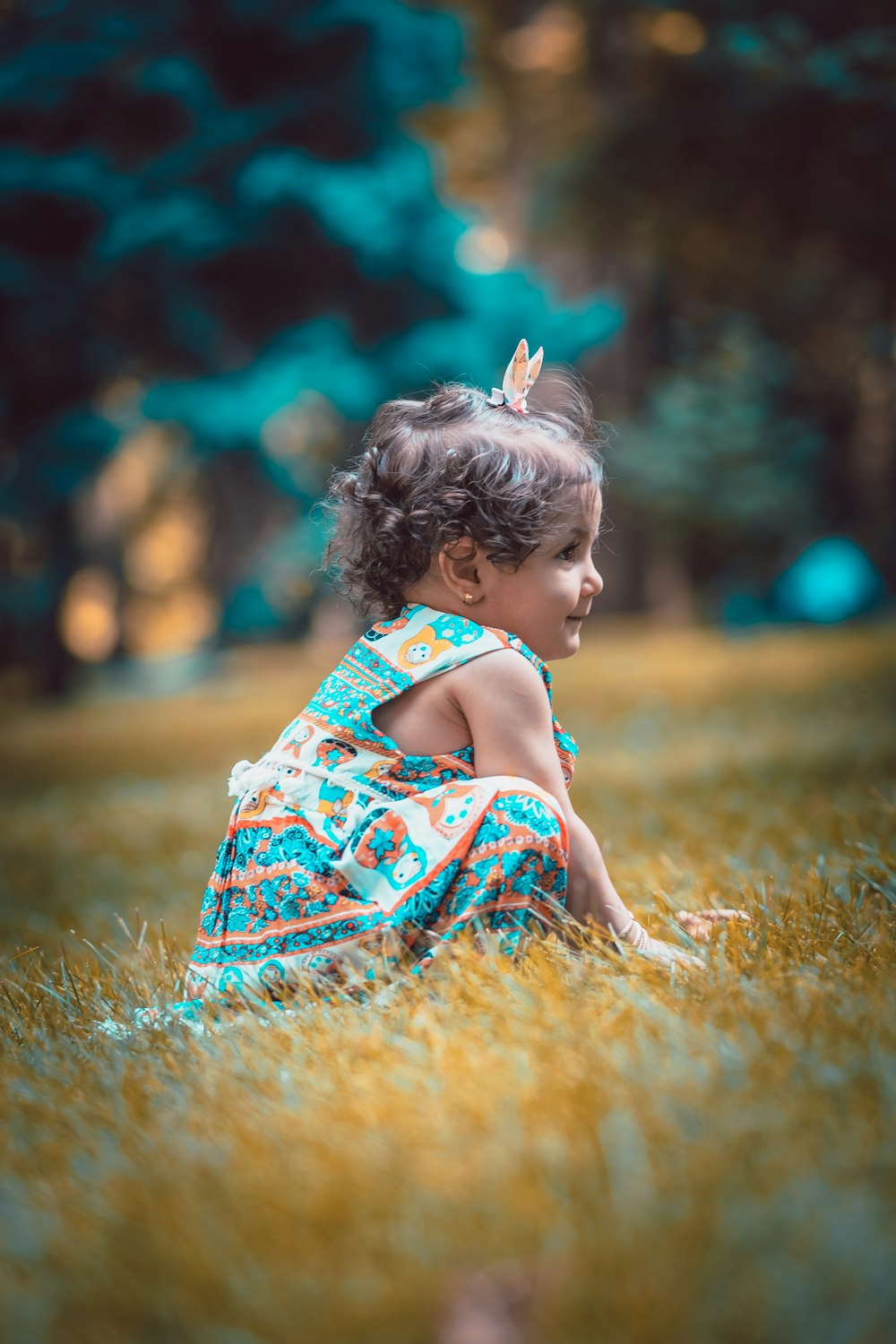 a little girl sitting in a field of tall grass