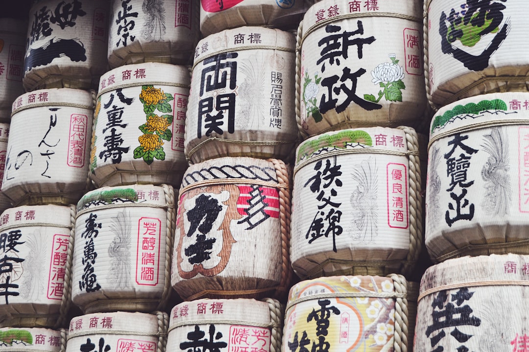 a large pile of rice with asian writing on it, Kazaridaru - Sake barrels at the Meiji shrine