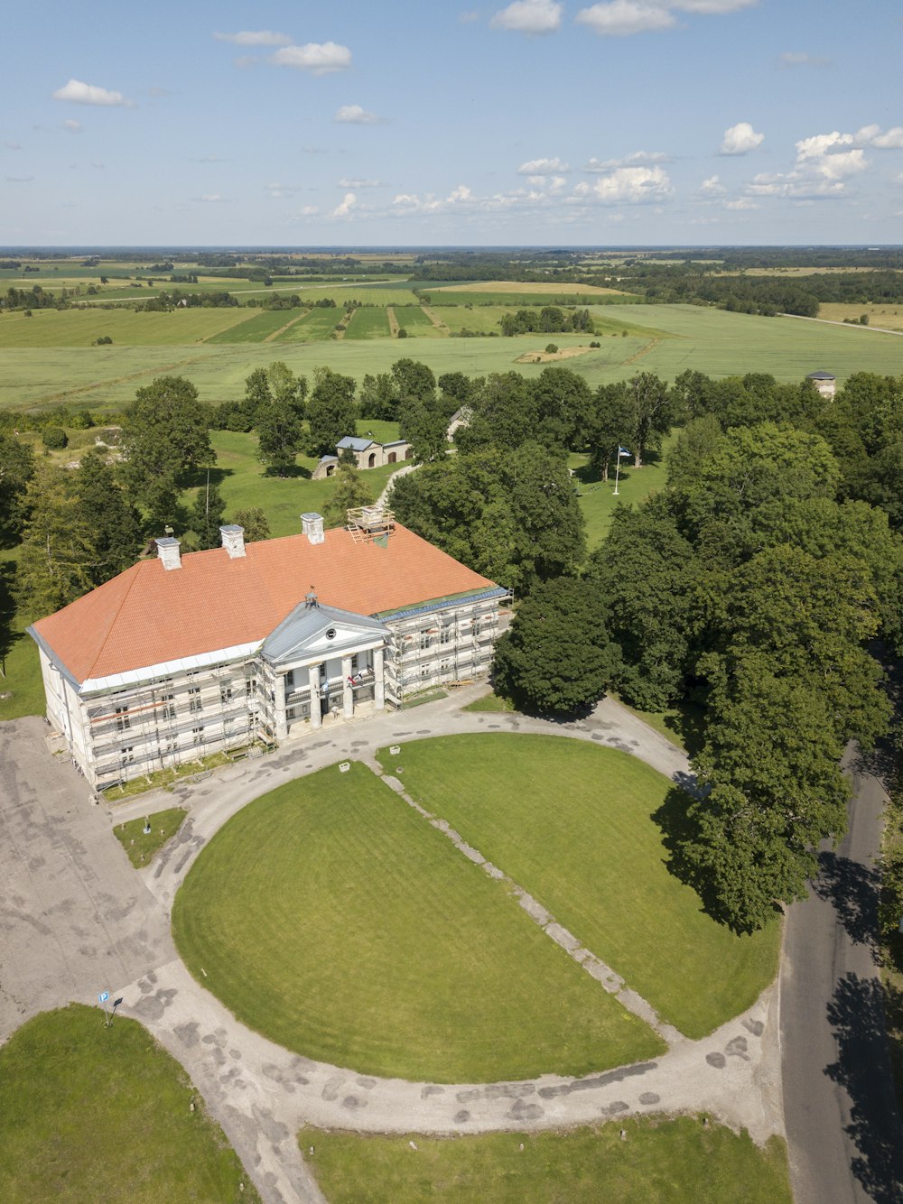 weißes und orangefarbenes Gebäude umgeben von Bäumen