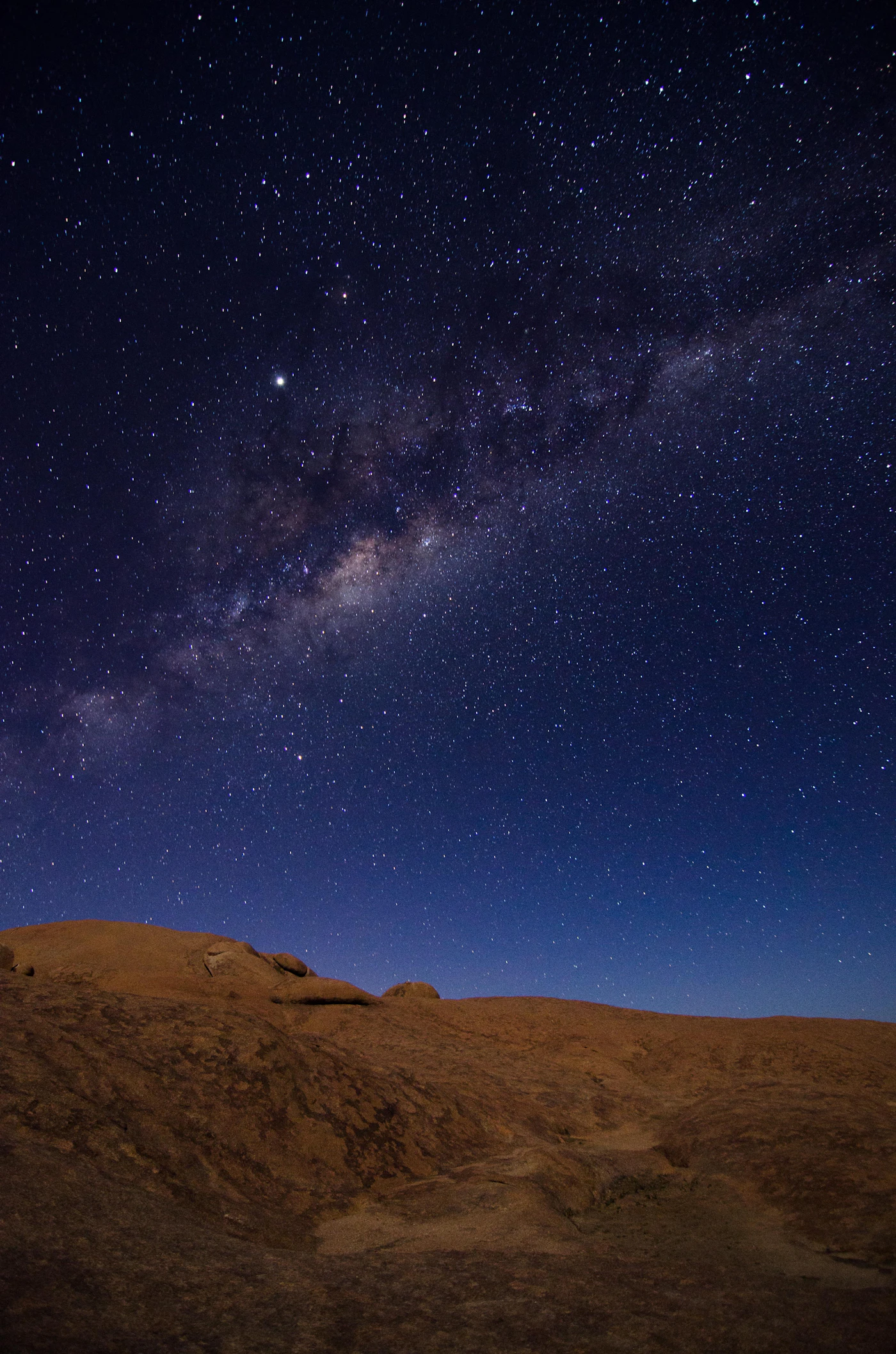 The Milky Way over an empty desert plain during the new-moon window, when the sky is at its darkest