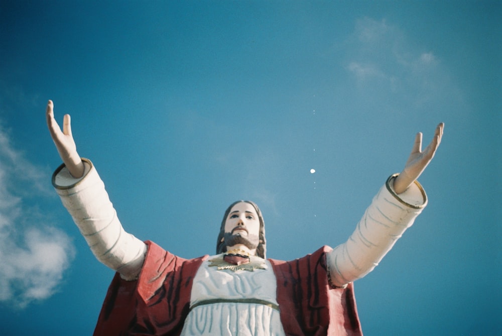 red and white Jesus monument under white and blue cloudy sky