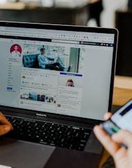 person using both laptop and smartphone