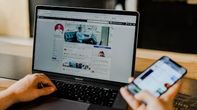 person using both laptop and smartphone