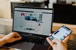 person using both laptop and smartphone von Austin Distel (https://unsplash.com/@austindistel)