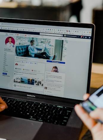 person using both laptop and smartphone