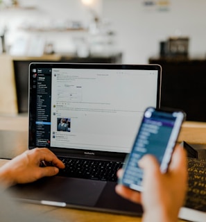 person using phone and laptop