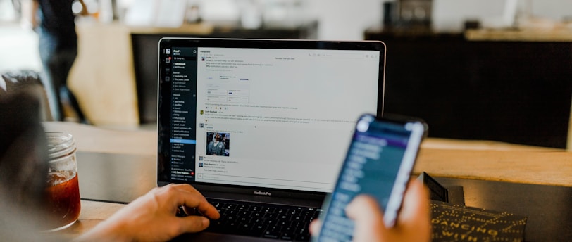 person using phone and laptop