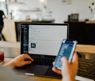 person using phone and laptop