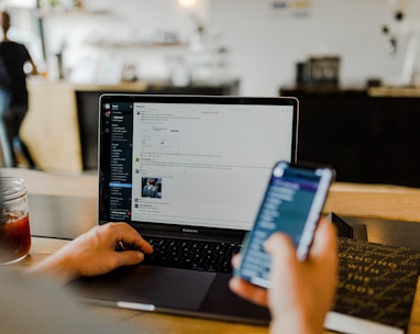 person using phone and laptop