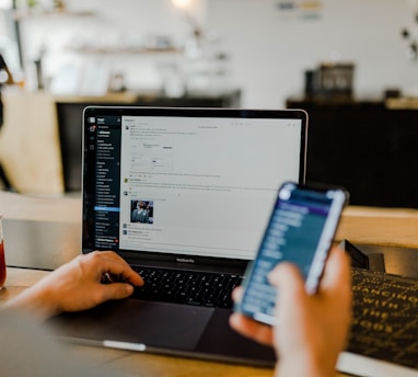 person using phone and laptop