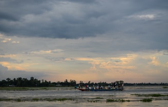 A group of travelers sharing a joyful moment during a sunset boat ride on the Godavari river.