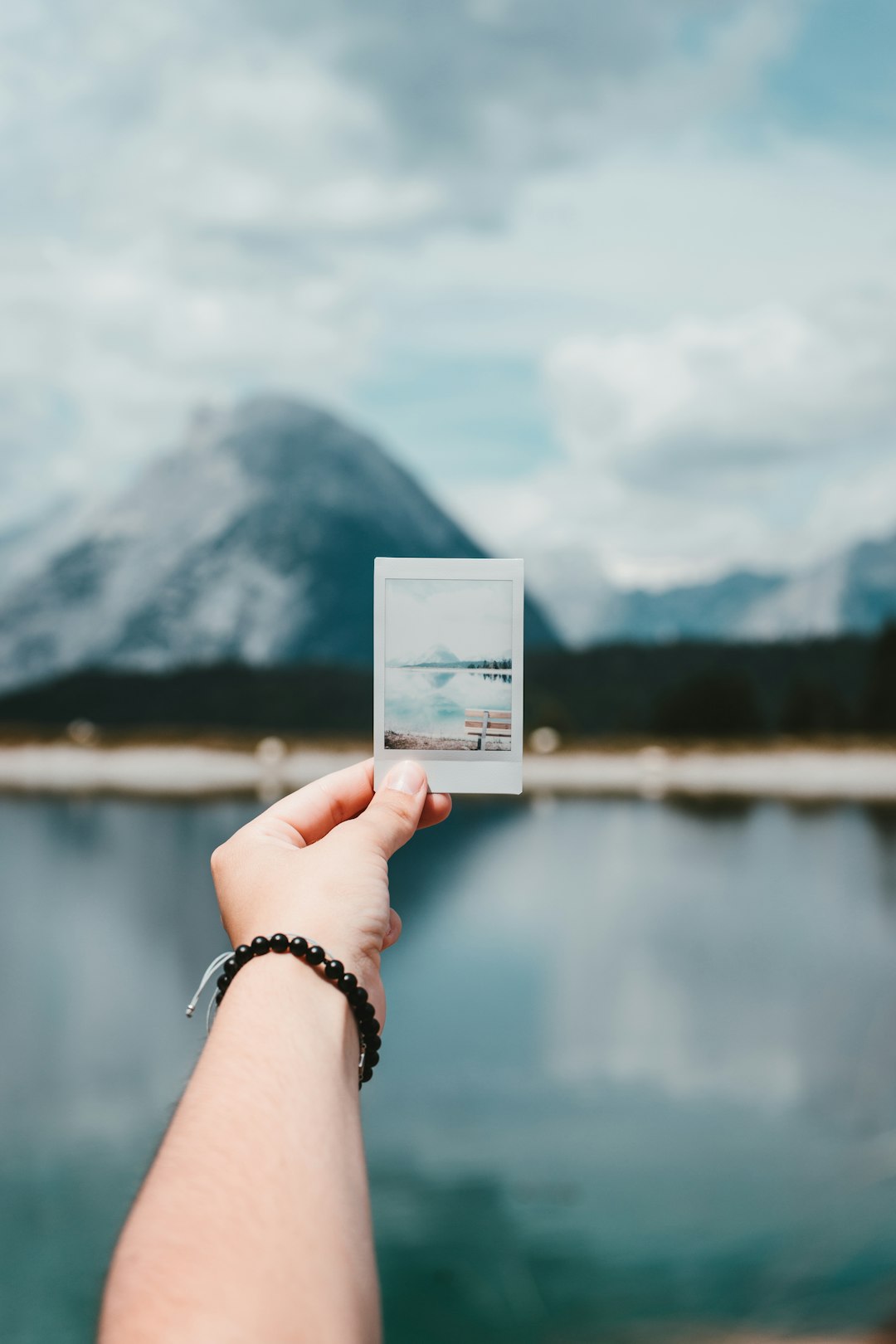 person holding photo of mountain