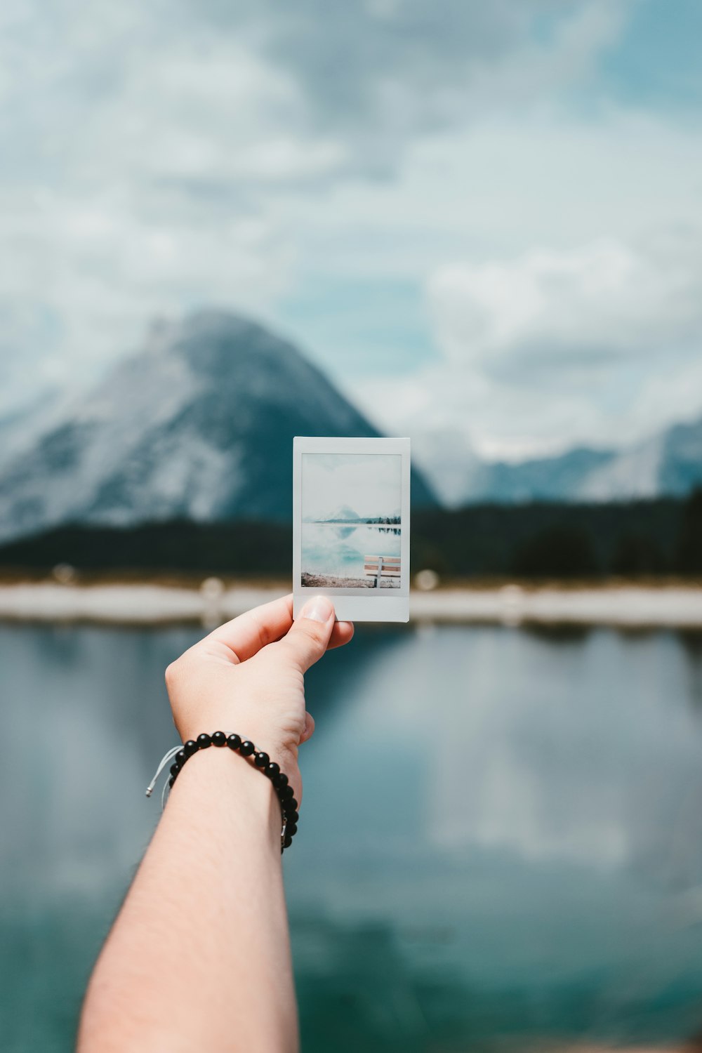 person holding photo of mountain