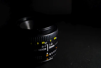 A cinematic shot of the camera aperture logo glowing subtly against a dark studio backdrop.