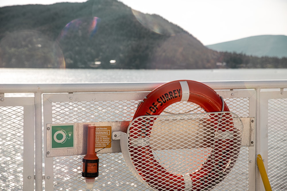 red and white life tube on white metal rail during daytime