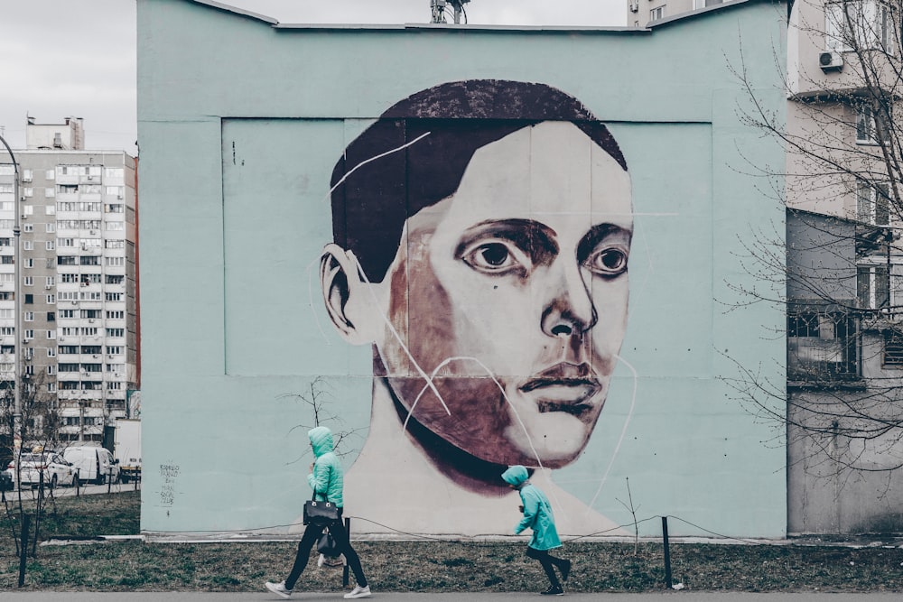 twp person near a wall painting during daytime