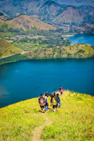 Teenagers hiking through lush green hills with backpacks and bright smiles.