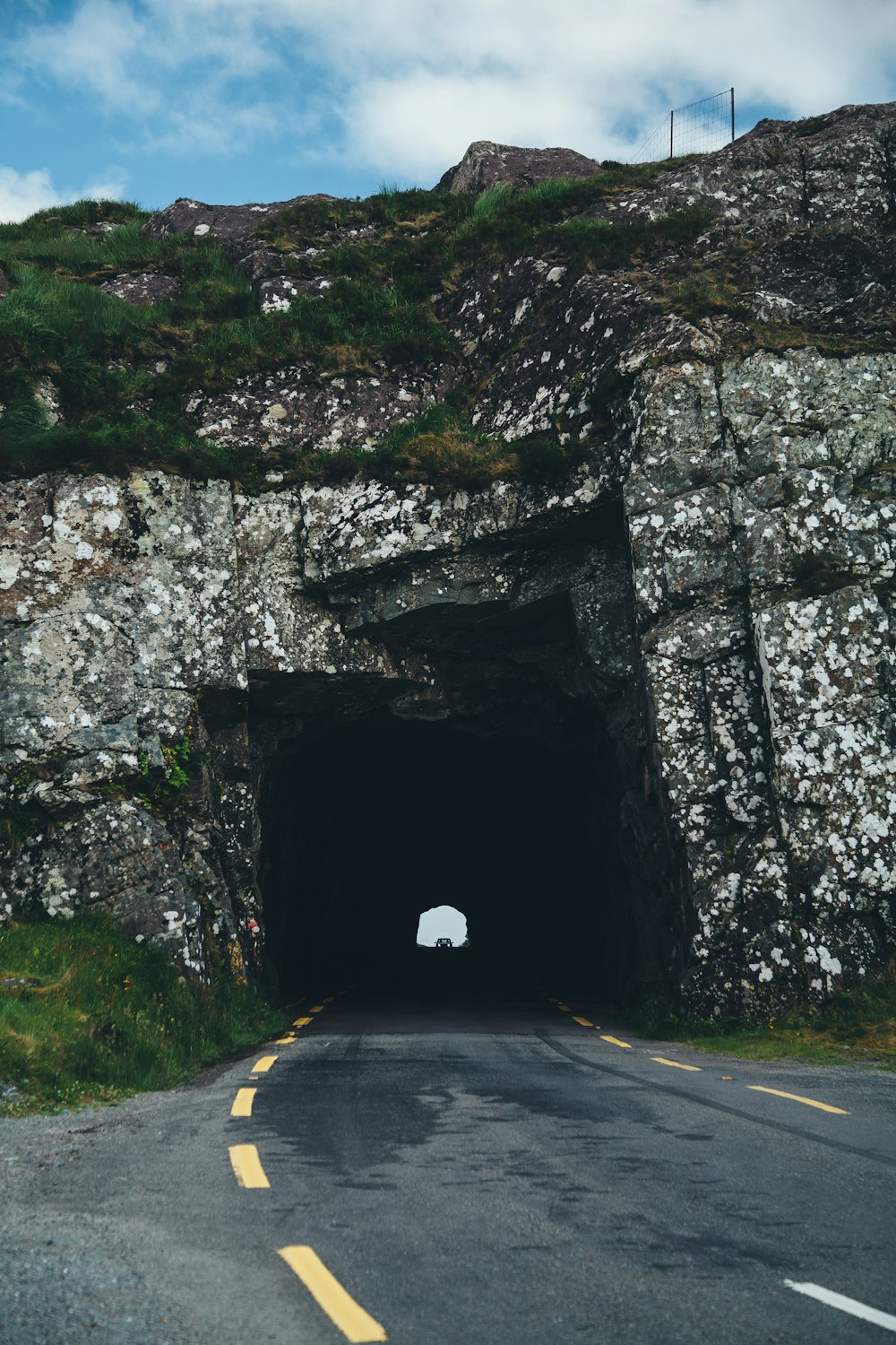 a car driving into a tunnel on a road
