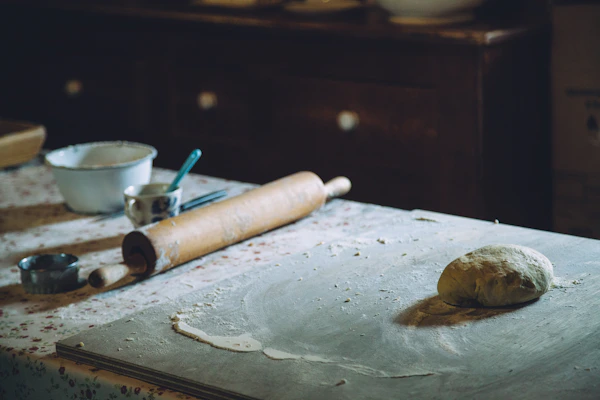 Step-by-step photo of mixing dough ingredients in a rustic kitchen setting.