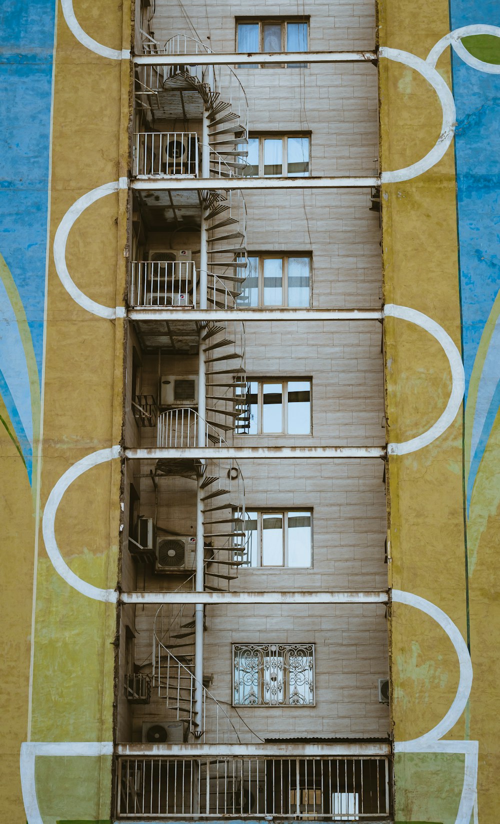 a tall building with a spiral staircase painted on it