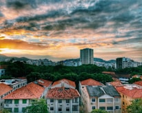 Photo of Catalão city skyline with warm orange and green hues at sunset.
