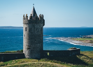 gray castle tower on mountain shore during day