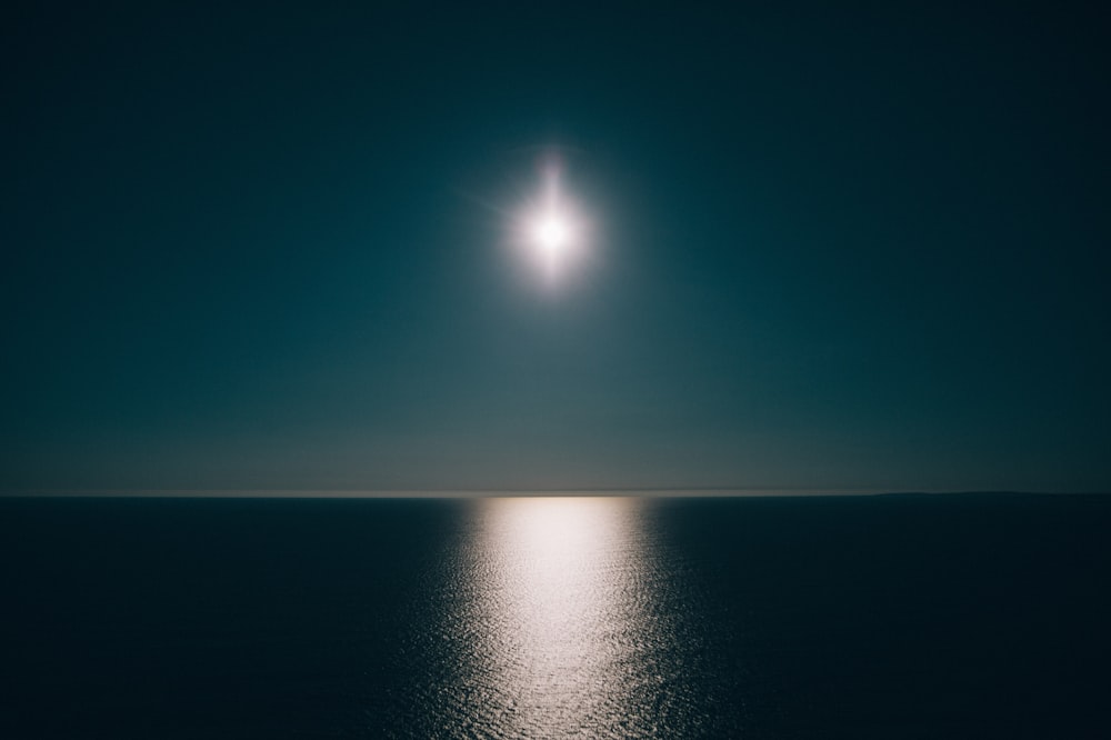 a full moon shines over the ocean at night