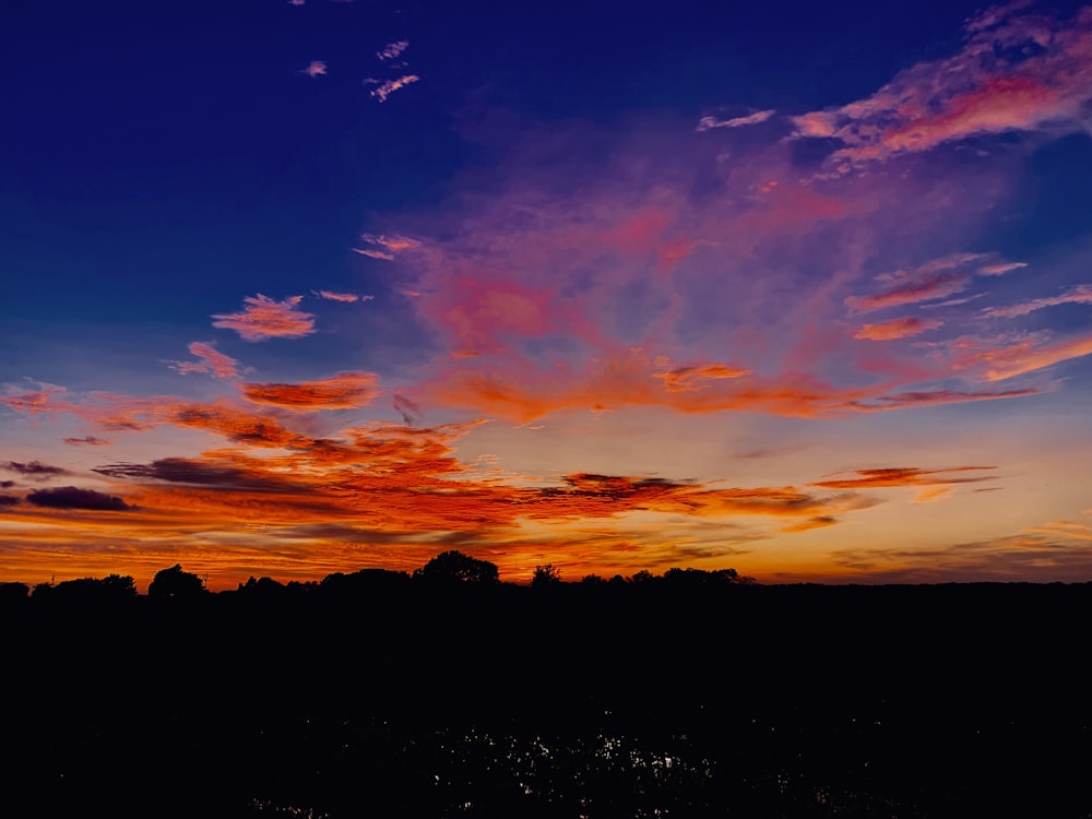 silhouette photo of orange clouds