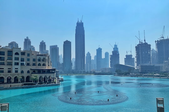 tall building near body of water during daytime in The Dubai Fountain United Arab Emirates