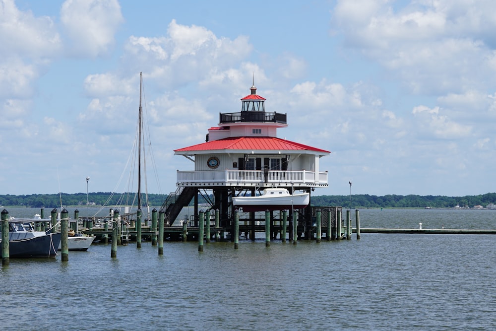 white and red house beside body of water at daytime