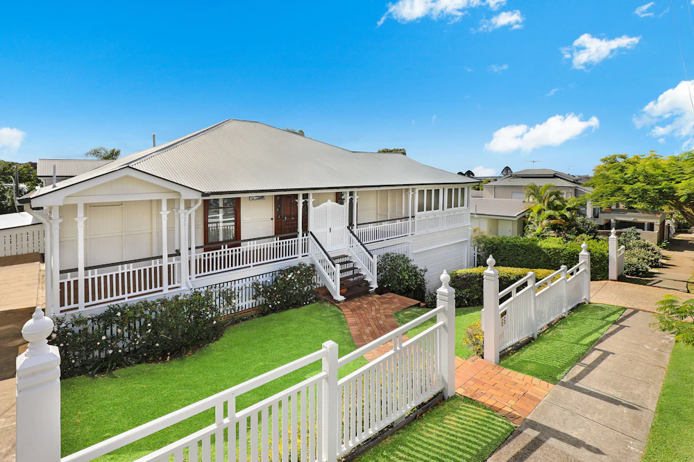 Front view of a white and brown family home and its yard