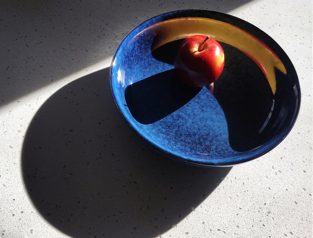 red apple on blue bowl