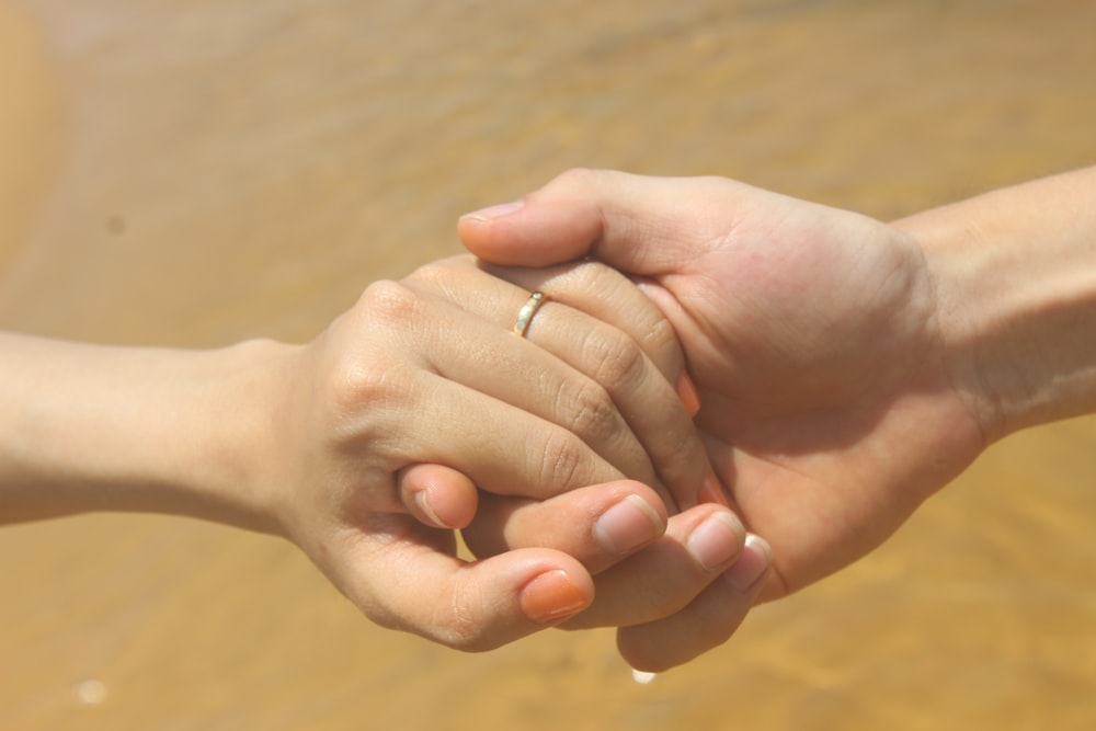 a close up of two people holding hands