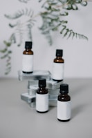 Elegant glass bottles filled with herbal oils and tinctures, set against a soft green background.
