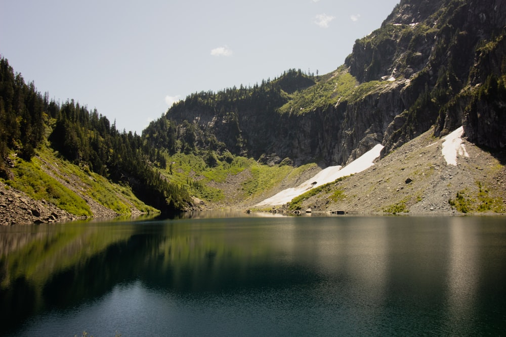 body of water near mountains during daytime