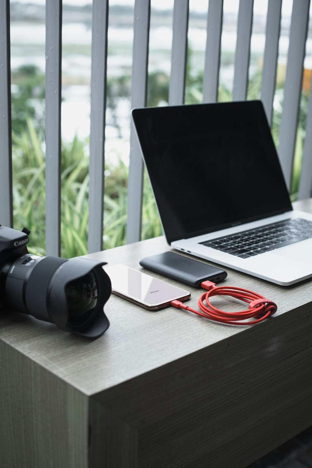 turned-off MacBook beside DSLR camera