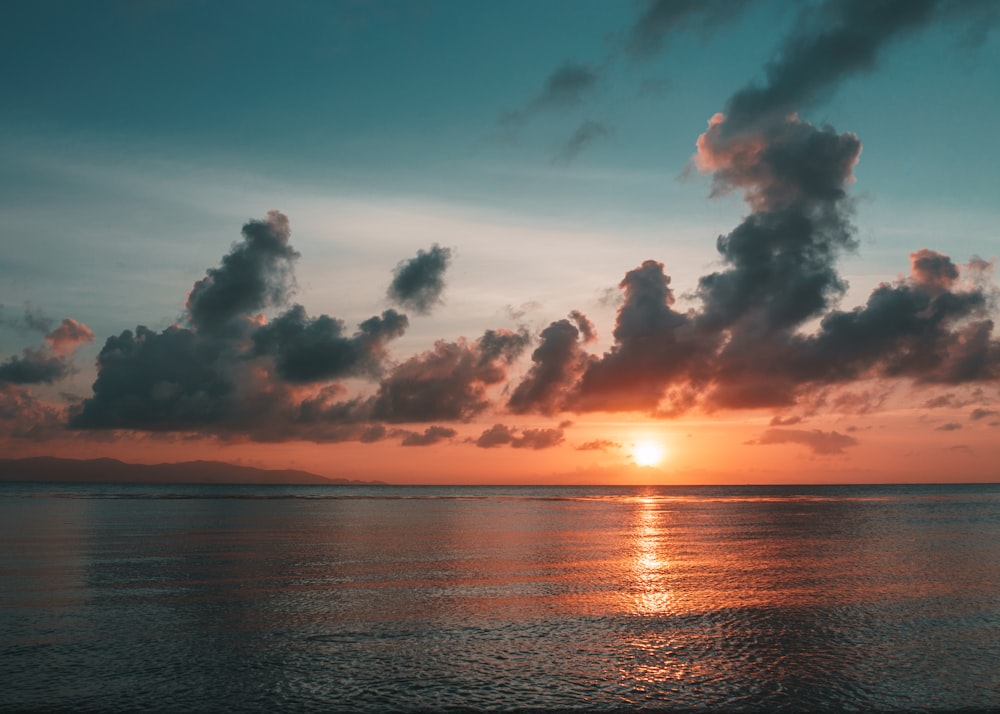 body of water across horizon during sunset