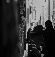 Black and white candid portrait of bouginz et bougzer walking through a graffiti-lined alley.