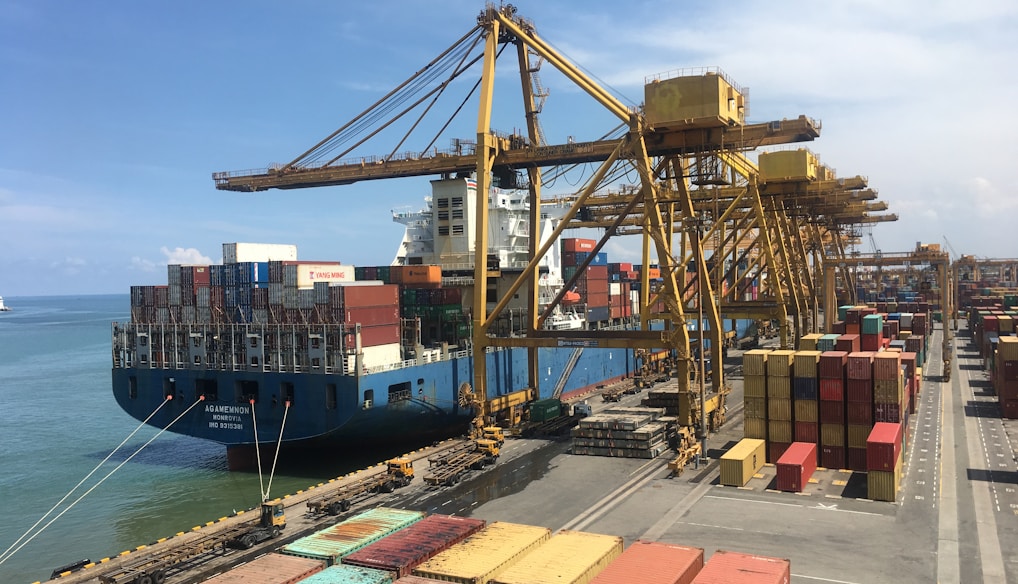 ship on dock near shipping containers