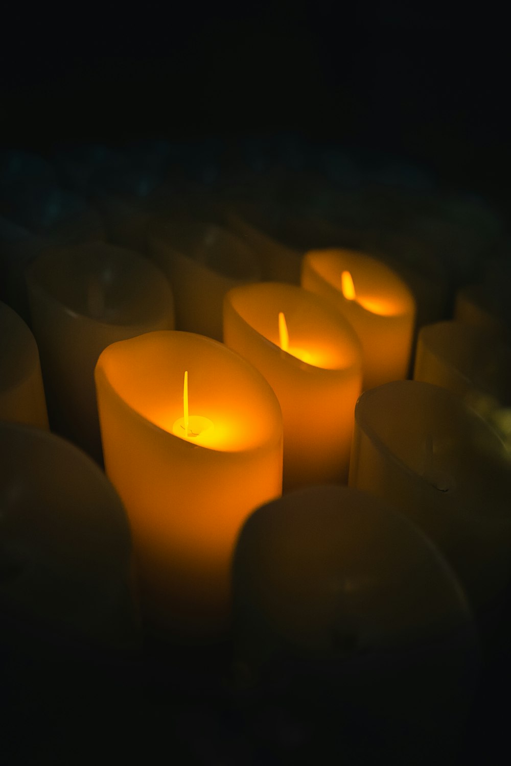 three yellow tealight candles