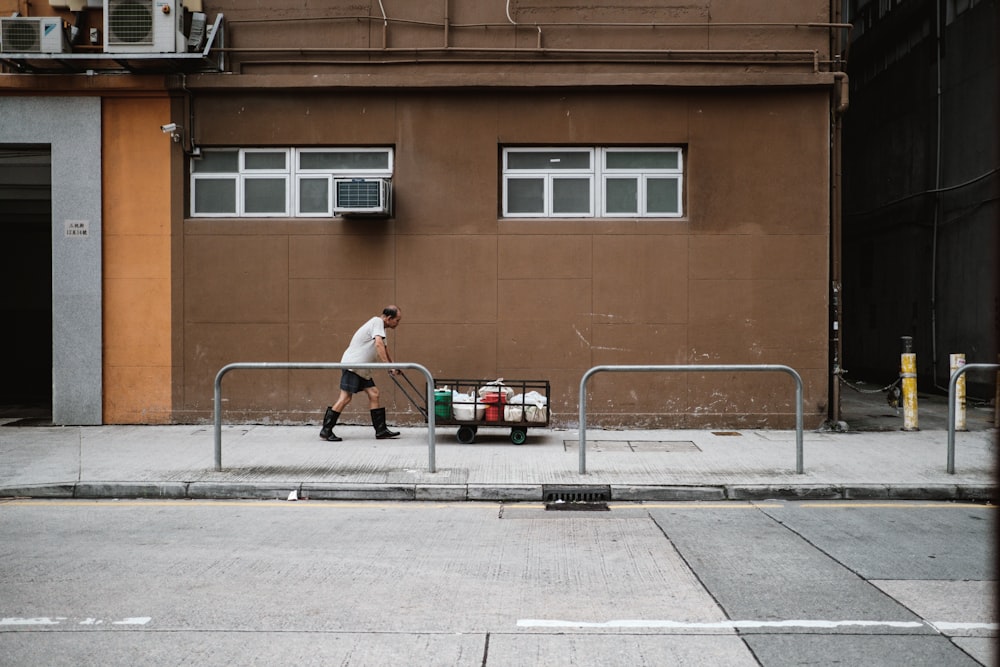 a man walking down a street past a building