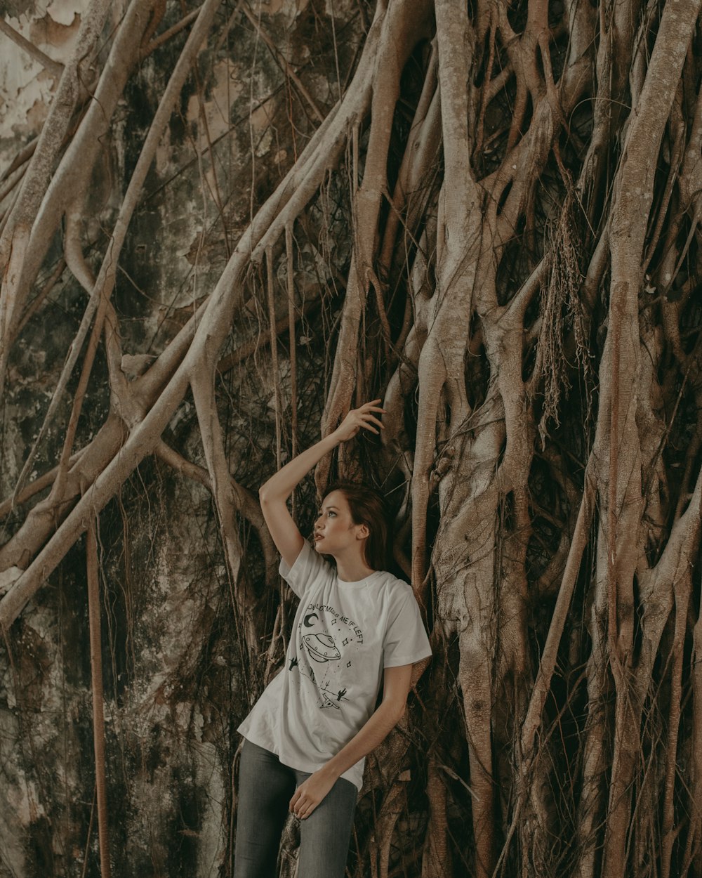 woman leaning beside tree