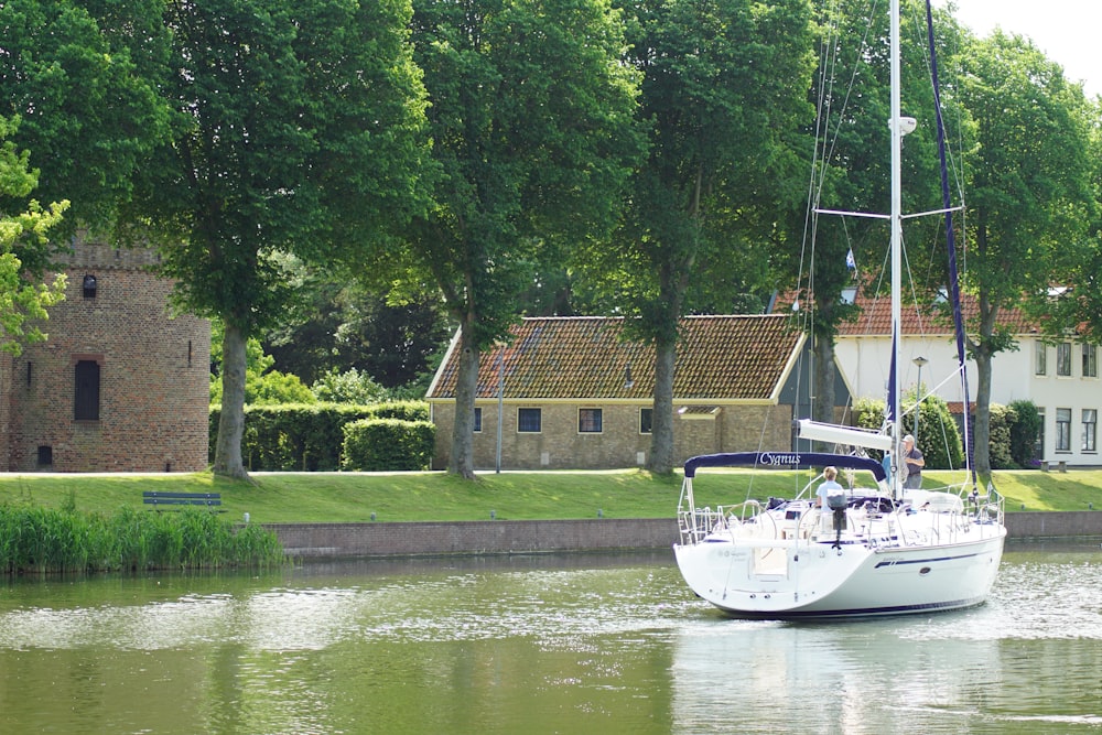 boat on body of water near tree during daytime