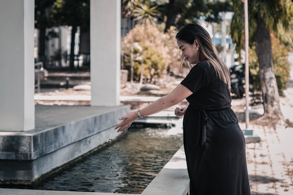 woman standing beside body of water